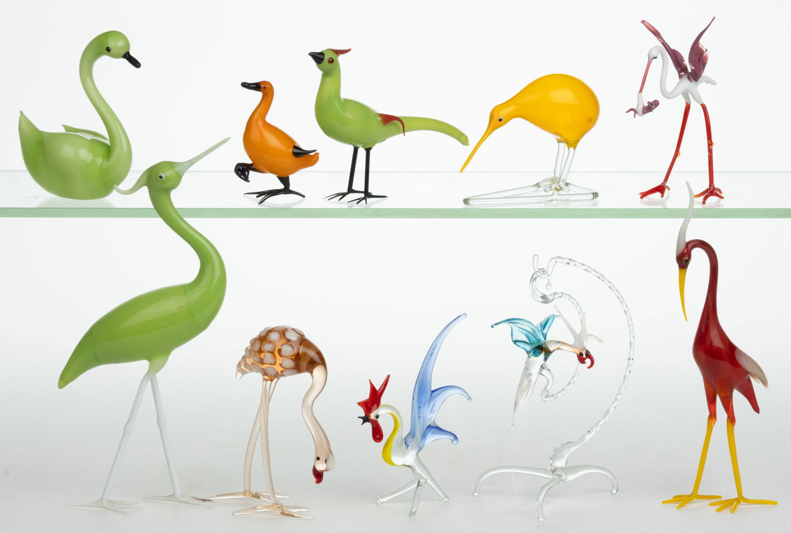ASSORTED GERMAN ART GLASS BIMINI-TYPE BIRD FIGURES, LOT OF TEN: ASSORTED GERMAN ART GLASS BIMINI-TYPE BIRD FIGURES, LOT OF TEN, various colors, including a stork holding a tiny baby, a flamingo, two herons, and a hanging parrot with a separate stand. 20th century.