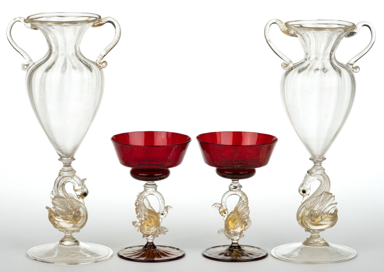ASSORTED MURANO / VENETIAN AVENTURINE-DECORATED SWAN-STEM GLASS ARTICLES, LOT OF FOUR: ASSORTED MURANO / VENETIAN AVENTURINE-DECORATED SWAN-STEM GLASS ARTICLES, LOT OF FOUR, comprising a pair of colorless urn-form vases and a pair of ruby and colorless champagnes, each with a
