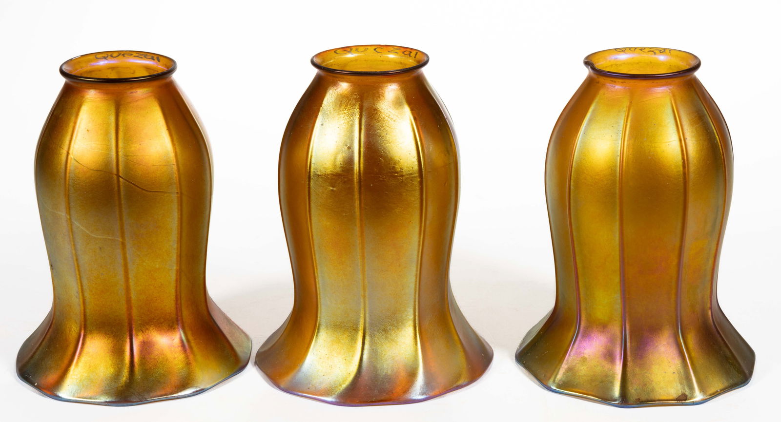 SIGNED "QUEZAL" RIBBED IRIDESCENT ART GLASS LAMP SHADES, SET OF THREE: SIGNED "QUEZAL" RIBBED IRIDESCENT ART GLASS LAMP SHADES, SET OF THREE, golden iridescent, lily form with vertical rib panels to the body, each signed "QUEZAL" to the inte