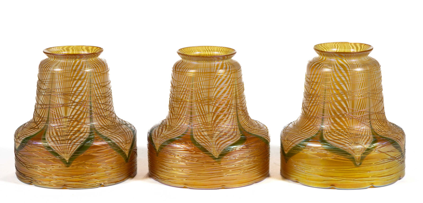 QUEZAL / DURAND ATTRIBUTED PULLED FEATHER ART GLASS LAMP SHADES, SET OF THREE: QUEZAL / DURAND ATTRIBUTED PULLED FEATHER ART GLASS LAMP SHADES, SET OF THREE, golden and green iridescent, overall spider-webbing, each of bell form with scalloped rims, each unsigned. Prob