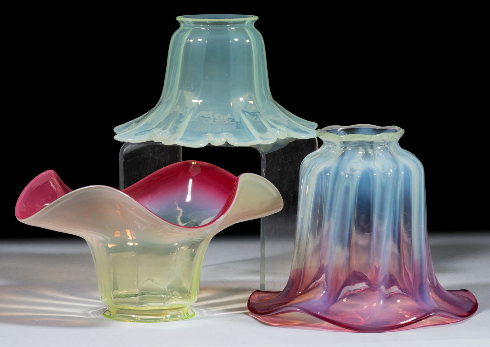 ASSORTED OPALESCENT ELECTRIC LAMP SHADES, LOT OF THREE: ASSORTED OPALESCENT ELECTRIC LAMP SHADES, LOT OF THREE, opalescent, and opalescent Rubina Verde (all react under blacklight), each vaguely of floral form, the smallest with a shaped petal edge, the ot