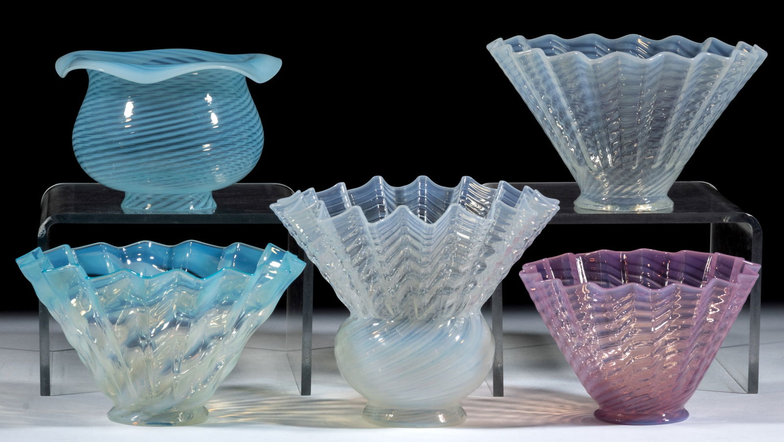 ASSORTED OPALESCENT SWIRL ELECTRIC LAMP SHADES, LOT OF FIVE: ASSORTED OPALESCENT SWIRL ELECTRIC LAMP SHADES, LOT OF FIVE, cranberry opalescent, colorless opalescent, and blue opalescent, including four petticoat shades with sharp angular pleats, and a bulbous e