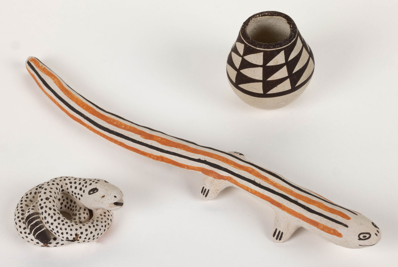 SIGNED LUCY LEWIS (1890-1992) NATIVE AMERICAN ACOMA PUEBLO POTTERY ARTICLES, LOT OF THREE: SIGNED LUCY LEWIS (1890-1992) NATIVE AMERICAN ACOMA PUEBLO POTTERY ARTICLES, LOT OF THREE, comprising a coiled spotted snake figurine, a miniature jar with geometric banded design, and an or