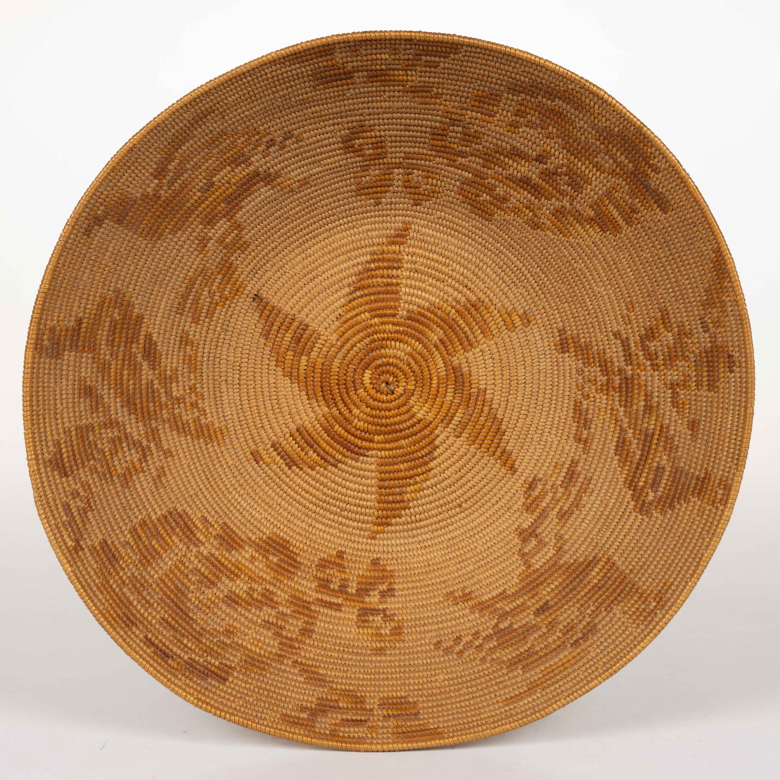 SOUTHWESTERN NATIVE AMERICAN JICARILLA APACHE BASKET: SOUTHWESTERN NATIVE AMERICAN JICARILLA APACHE BASKET, woven with fibers and natural dyes, in round form with a center star surrounded by bird designs. First quarter 20th century. 3 1/8"