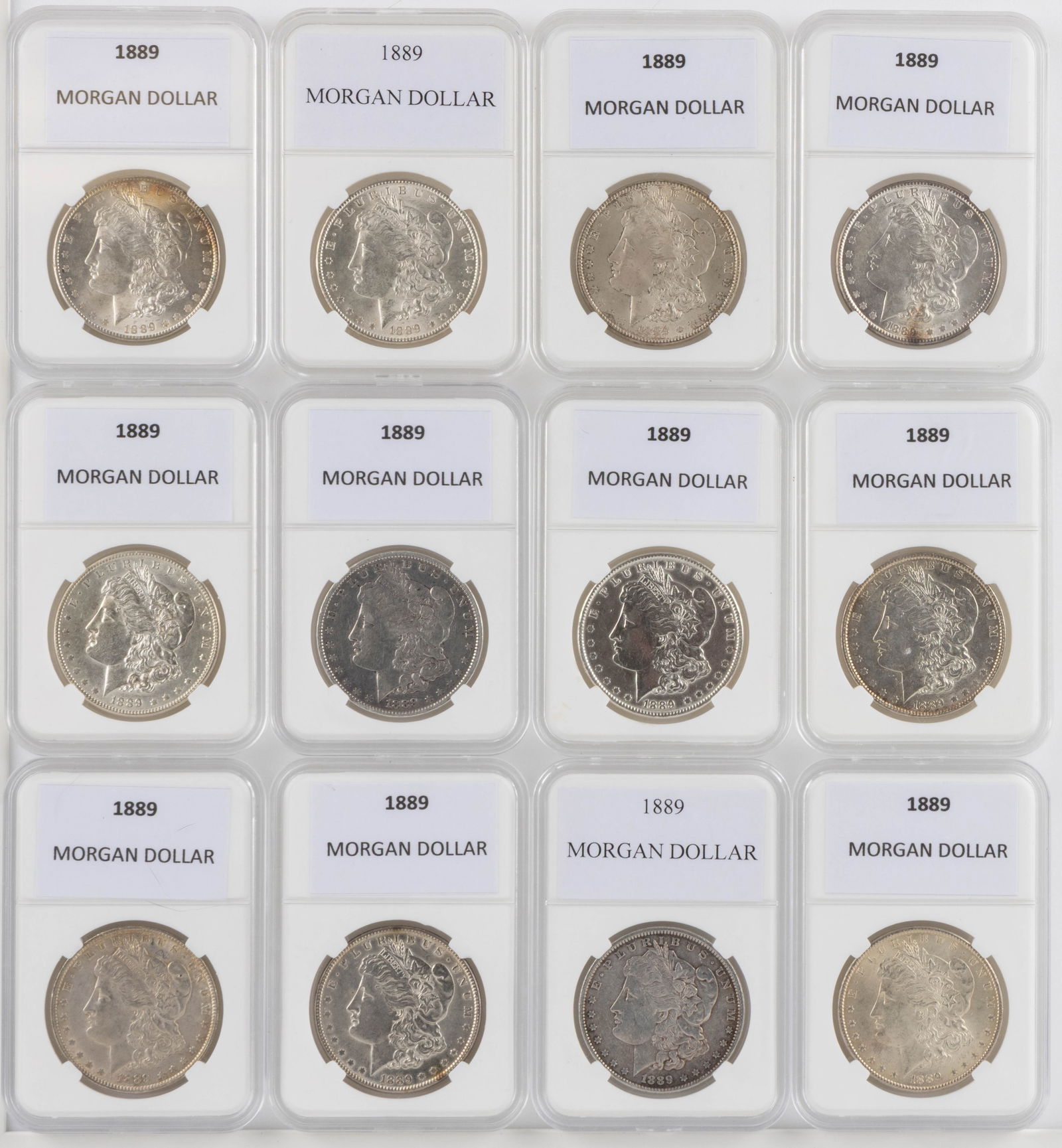 UNITED STATES 1889 MORGAN SILVER DOLLAR COINS, LOT OF 12: UNITED STATES 1889 MORGAN SILVER DOLLAR COINS, LOT OF 12, each housed in a plastic presentation case. Provenance: From the collection of a prominent Northern VA gentleman.
