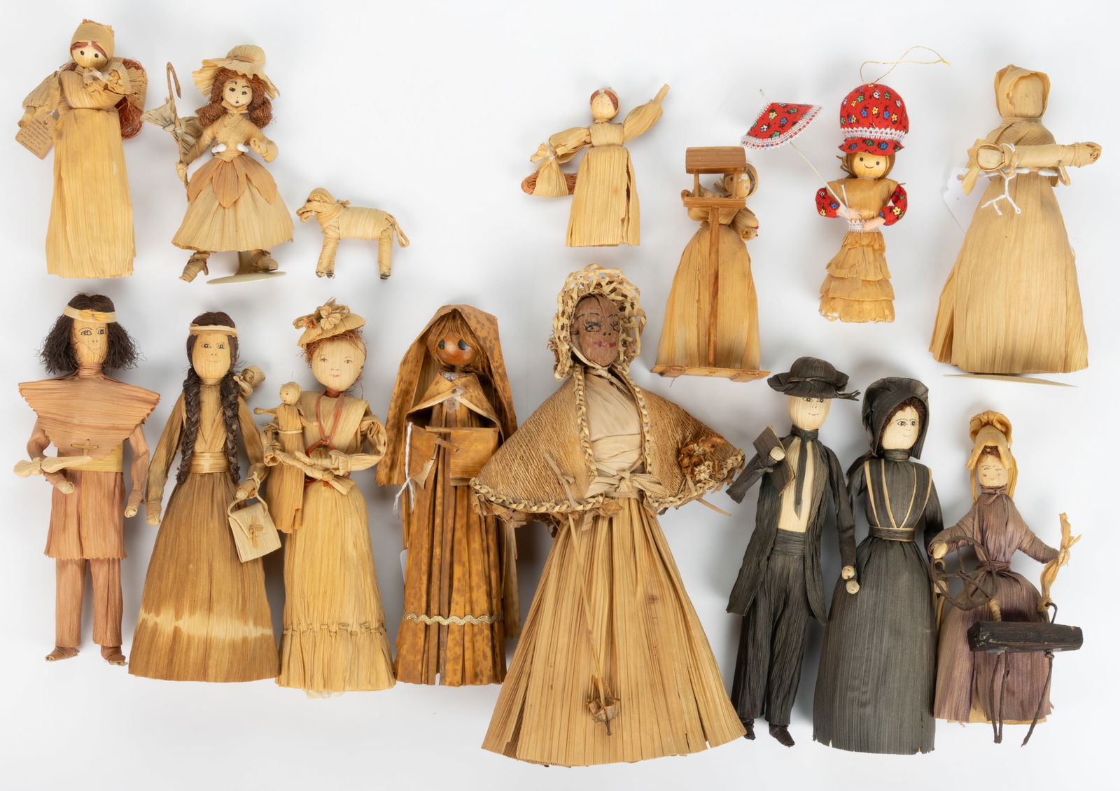 ASSORTED VINTAGE CORN HUSK DOLLS, LOT OF 15: ASSORTED VINTAGE CORN HUSK DOLLS, LOT OF 15, each with various facial features and mostly painted; including a couple in dark stained clothing, man is in a suit with book and lady in a dress