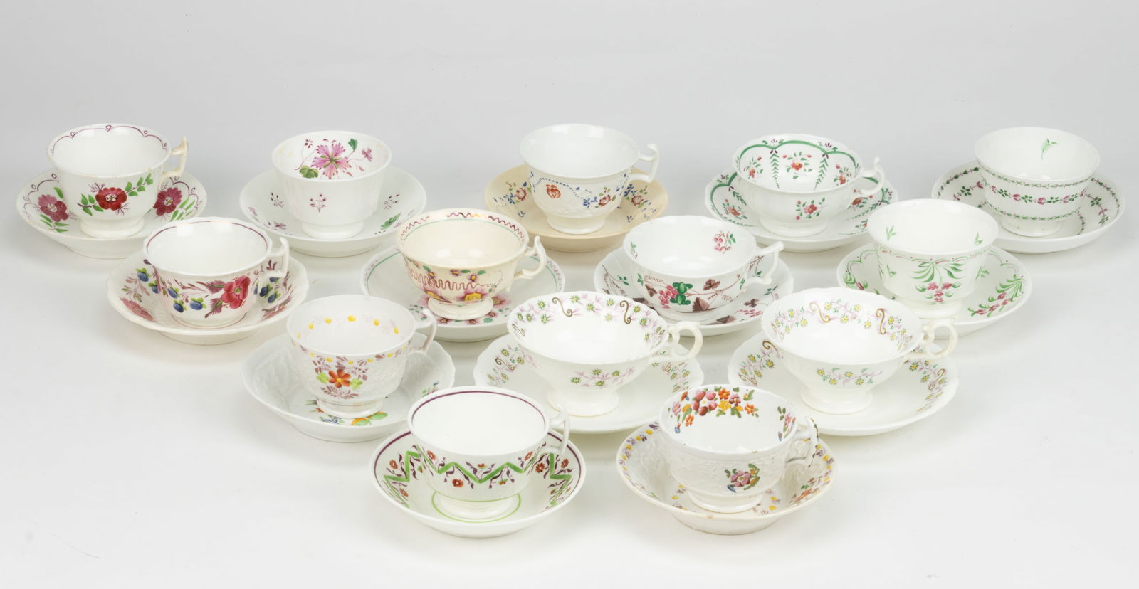 BRITISH HAND-PAINTED CERAMIC FLORAL MOTIF CUP AND SAUCER SETS, LOT OF 14: BRITISH HAND-PAINTED CERAMIC FLORAL MOTIF CUP AND SAUCER SETS, LOT OF 14, each having polychrome decorations, including one example with grape bunch motif, two sets having matching delicate green and