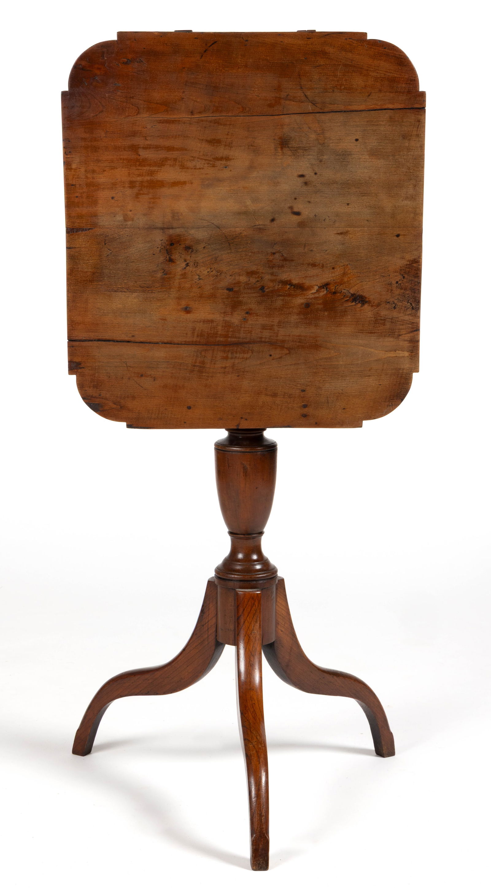 AMERICAN LATE FEDERAL CHERRY TILT-TOP CANDLESTAND: AMERICAN LATE FEDERAL CHERRY TILT-TOP CANDLESTAND, the shaped rectangular top with a battens applied to the underside hinged to a block over a turned standard, the whole raised on simple
