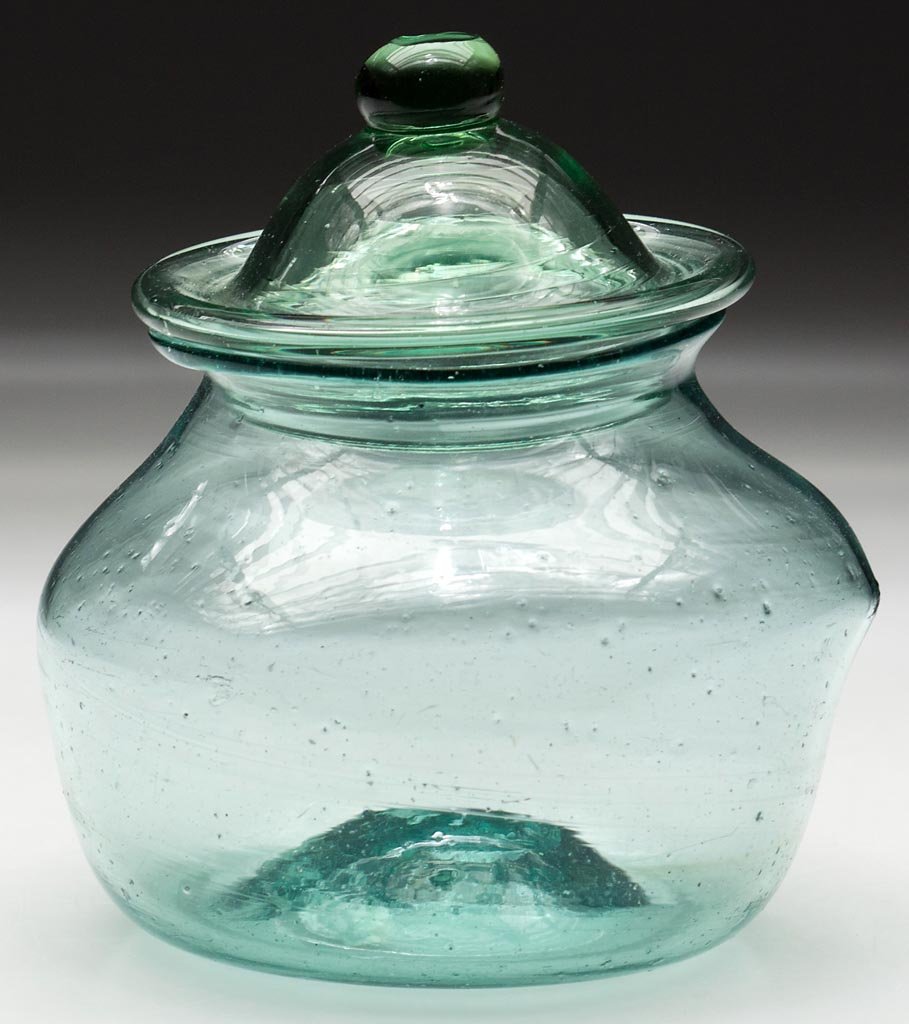 FREE-BLOWN SUGAR BOWL AND COVER: FREE-BLOWN SUGAR BOWL AND COVER, aquamarine and light green, crude compressed globular body with a flared rim and kick-up base with rough pontil mark, domed cover with pinched flange and drawn solid-k