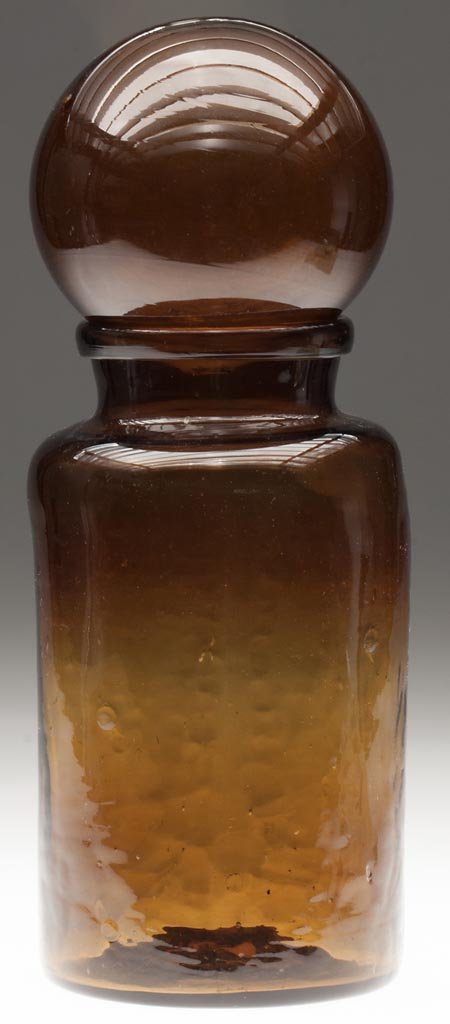 FREE-BLOWN STORAGE JAR AND BALL COVER: FREE-BLOWN STORAGE JAR AND BALL COVER, amber with a slight yellow tone, cylindrical form with sharp shoulder, heavy folded mouth, and rough pontil mark, with an amber ball cover having an open rough p