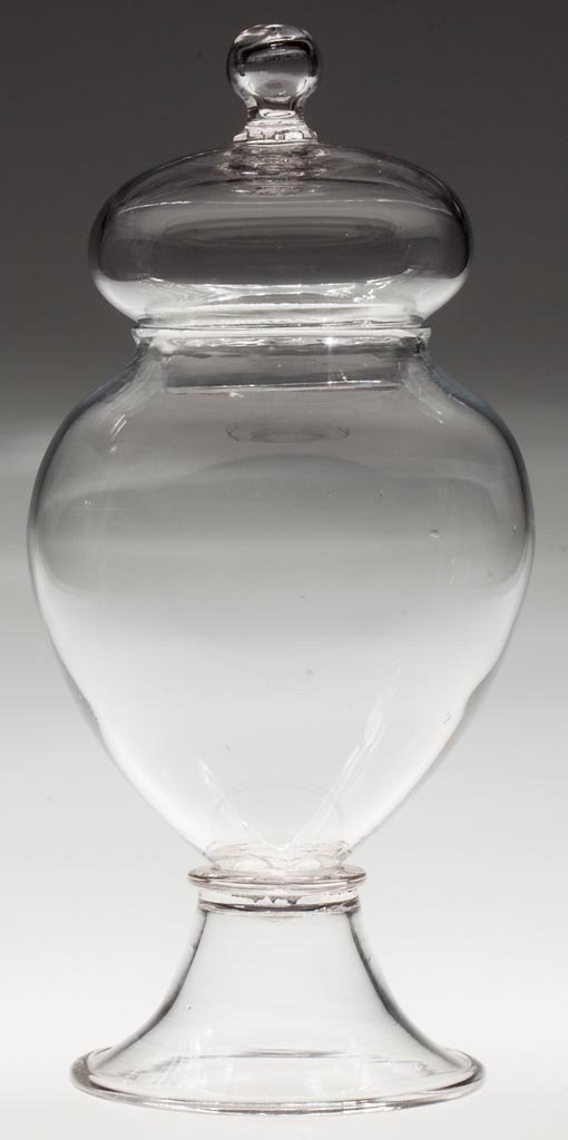 FREE-BLOWN APOTHECARY OR SHOW JAR: FREE-BLOWN APOTHECARY OR SHOW JAR, colorless, deep ovoid bowl raised on a funnel foot with folded rim and rough pontil mark, cover with an applied hollow-ball finial with interior rough pontil mark. U