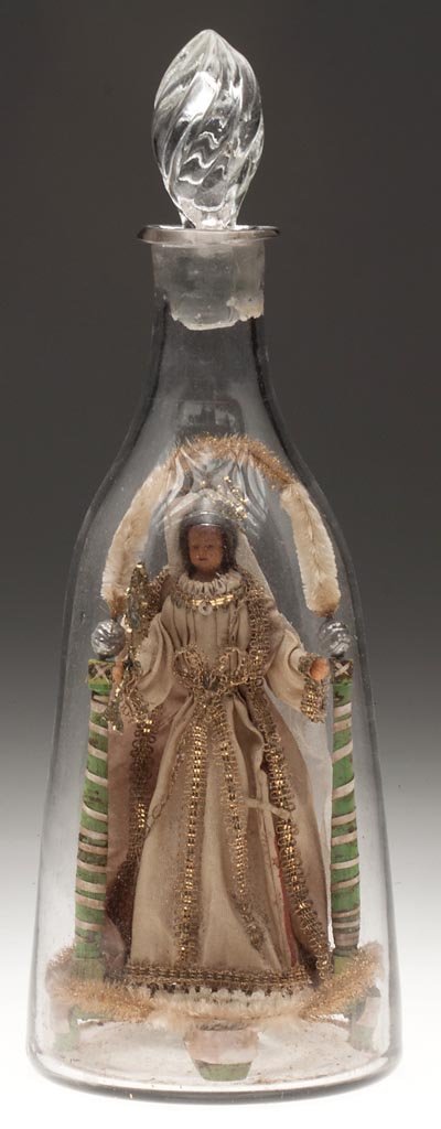 FREE-BLOWN WHIMSY WAX DOLL MAGNUM DECANTER: FREE-BLOWN WHIMSY WAX DOLL MAGNUM DECANTER, colorless, undecorated taper-form with rough pontil mark and later pressed stopper. Enclosing a wax doll depicting a queen standing within an arch supported