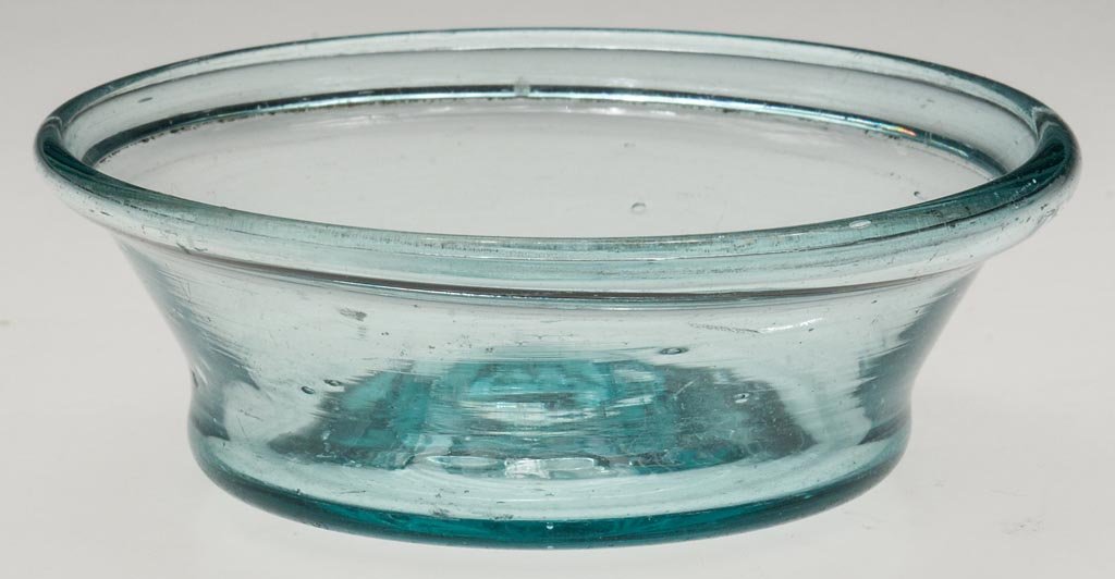 FREE-BLOWN DIMINUTIVE PATTY PAN: FREE-BLOWN DIMINUTIVE PATTY PAN, aquamarine, flared form with folded rim, slight kick-up base with rough pontil mark. Pittsburgh area and others. 1800-1850. 1 1/4" H, 3 7/8" D. Provenance: Collection 