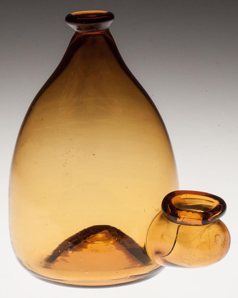 FREE-BLOWN BIRD FONT: FREE-BLOWN BIRD FONT, honey amber, conical form with button finial, protruding trough with applied rim, and kick-up base with rough pontil mark. 19th century. 5 1/2" H, 3 1/2" D.
