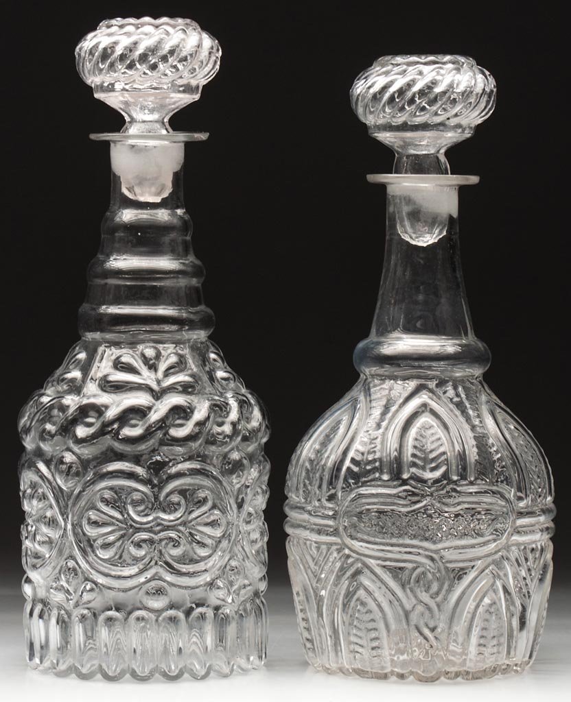 BLOWN-MOLDED QUART DECANTERS, LOT OF TWO: BLOWN-MOLDED QUART DECANTERS, LOT OF TWO, colorless, comprising a GIV-7 and a GV-14 variant without the neck crosshatching, each with rough pontil mark and appropriate swirl stopper. Boston & Sandwich