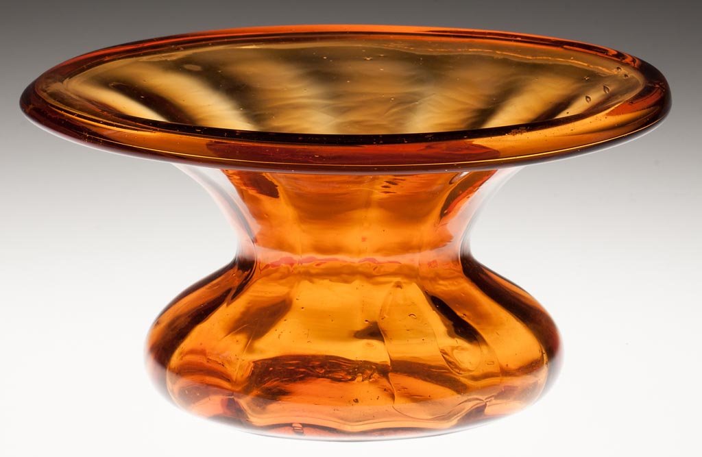 PATTERN-MOLDED SPITTOON: PATTERN-MOLDED SPITTOON, golden amber, lightly patterned with 12 vertical flutes which stop short of the folded rim, rough pontil mark. 19th century. 4 1/2" H, 8 1/2" D. Provenance: From a North Carol