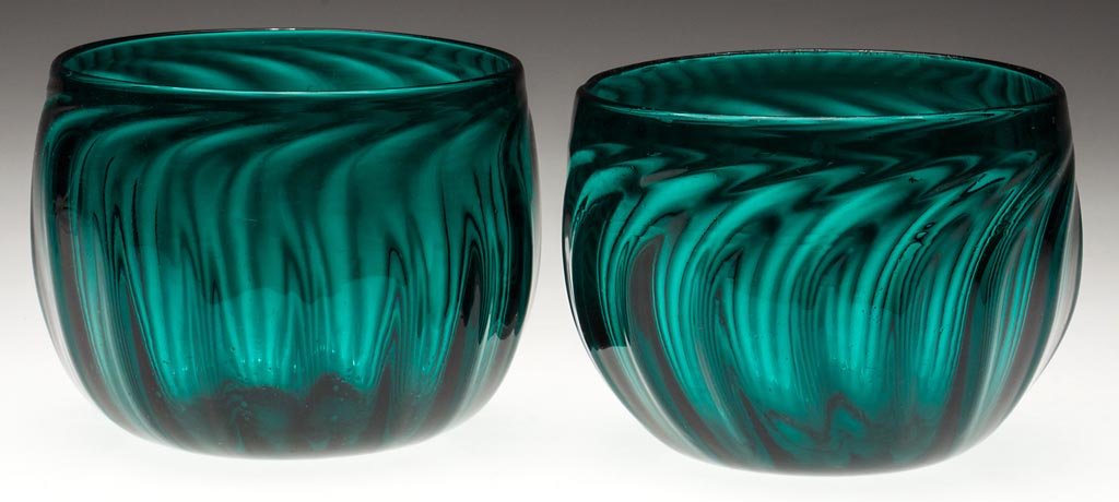 PAIR OF PILLAR-MOLDED FINGER BOWLS: PAIR OF PILLAR-MOLDED FINGER BOWLS, deep emerald green lead glass, each hemispherical bowl molded with 16 ribs swirled to the right at the plain rim, polished pontil mark. Second half 19th century. 3 