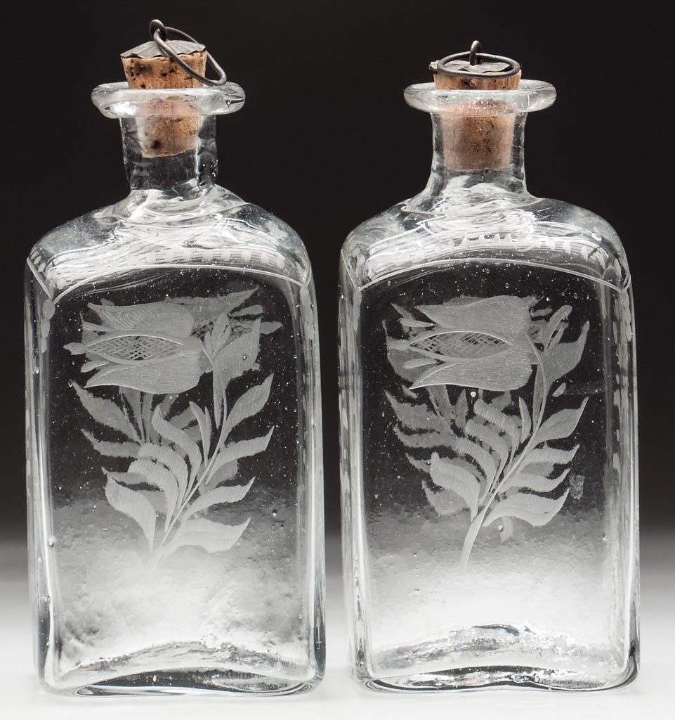 PAIR OF BLOWN AND ENGRAVED CORDIAL BOTTLES: PAIR OF BLOWN AND ENGRAVED CORDIAL BOTTLES, colorless, each blown in the half-post method and engraved with a tulip on two sides, thick folded mouths and rough pontil marks. Late 18th/early 19th centu