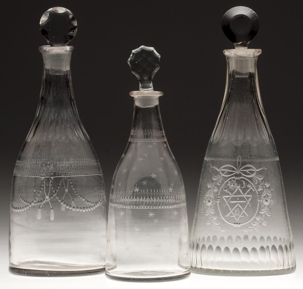 BLOWN AND ENGRAVED TAPER DECANTERS, LOT OF THREE: BLOWN AND ENGRAVED TAPER DECANTERS, LOT OF THREE, colorless, comprising one pint and two quart examples, one with Masonic ornamentation, each with a pressed and cut stopper. Fourth quarter 18th/early 