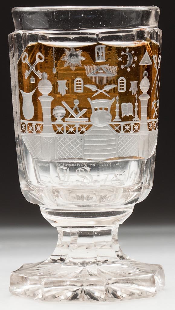 CUT AND ENGRAVED MASONIC FOOTED TUMBLER: CUT AND ENGRAVED MASONIC FOOTED TUMBLER, colorless with amber staining, panelled bowl engraved with Masonic symbols on a raised reserve above initials and 1859, reverse with a building within a landsc