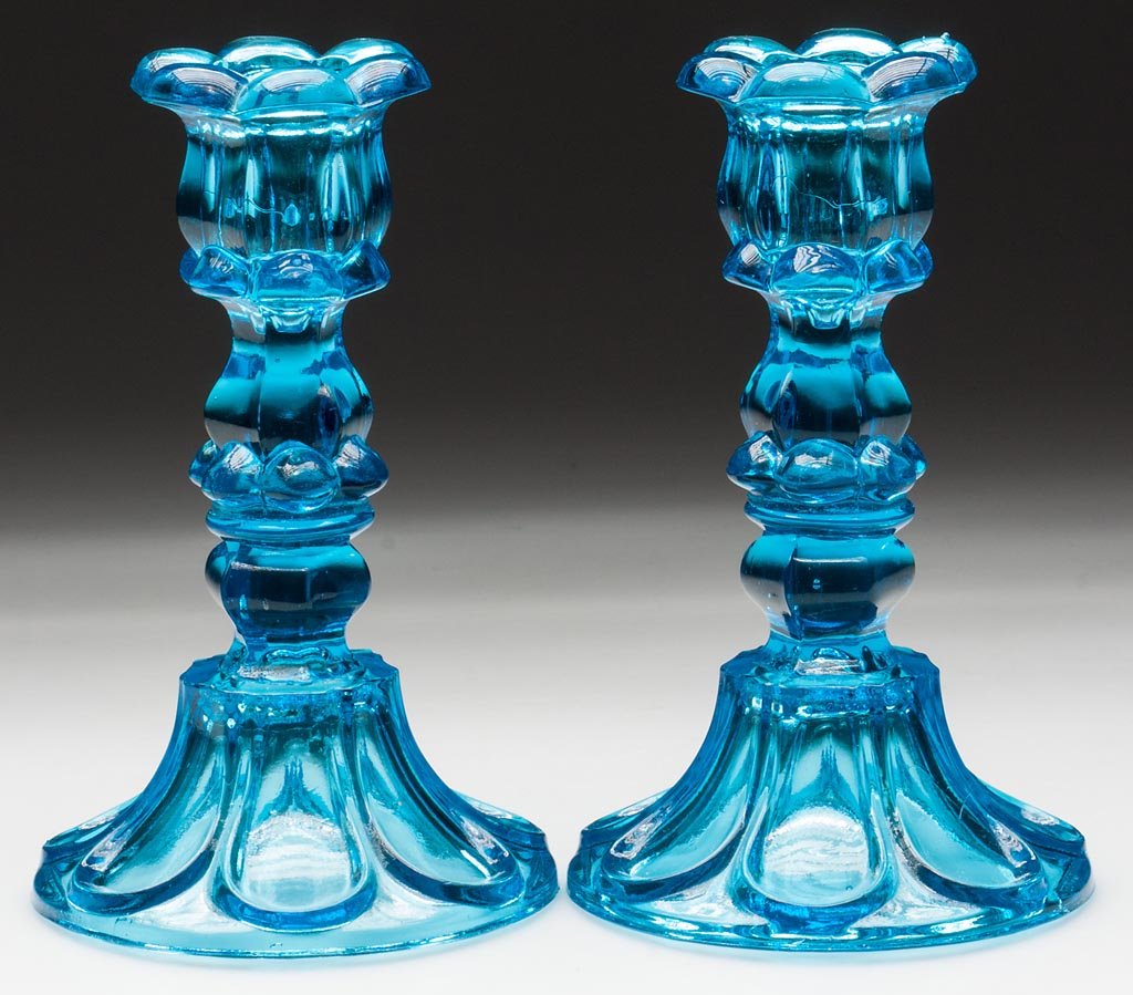 PAIR OF PRESSED PETAL AND LOOP CANDLESTICKS: PAIR OF PRESSED PETAL AND LOOP CANDLESTICKS, brilliant electric blue, each six-petal socket with a hexagonal extension, raised on a hexagonal knop and seven-loop circular base with rough pontil mark, 