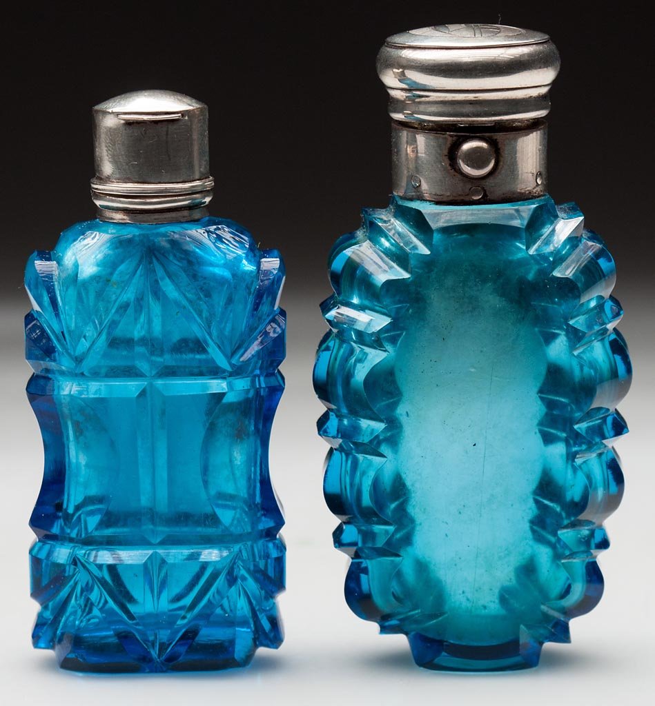 NOTCH-CUT SCENT BOTTLES, LOT OF TWO: NOTCH-CUT SCENT BOTTLES, LOT OF TWO, electric blue, each with hinged silver-like cap, no marks located, one interior stopper, polished bases. Second half 19th century. 3 1/4" and 3 1/2" HOA. Provenanc