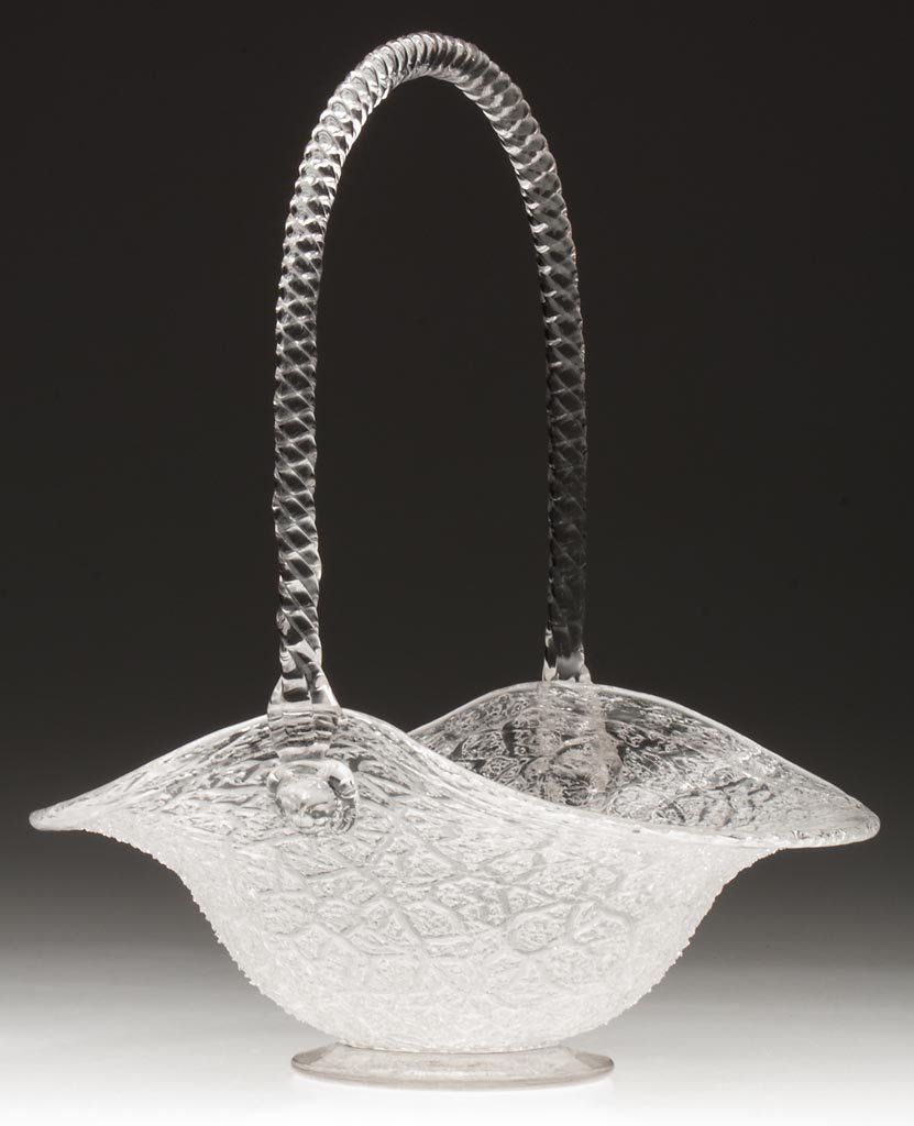 OVERSHOT BASKET: OVERSHOT BASKET, colorless, bowl with folded rim and applied high twisted-rope handle with mask prunts, raised on an applied foot with polished pontil mark. Boston & Sandwich Glass Co. Circa 1874. 12 