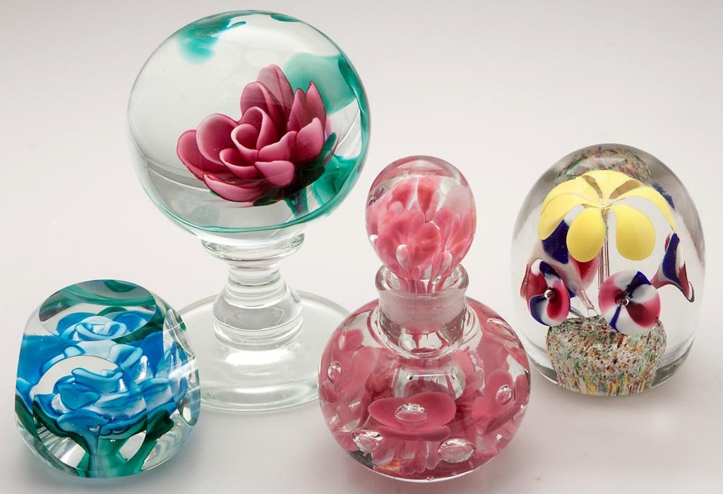ASSORTED PAPERWEIGHTS, LOT OF FOUR: ASSORTED PAPERWEIGHTS, LOT OF FOUR, including a pedestaled Millville Rose signed "Miles Larson, Millville N.J." and a St. Claire cologne bottle. Second half 20th century. 2 1/4" to 5 1/2" H. Provenanc