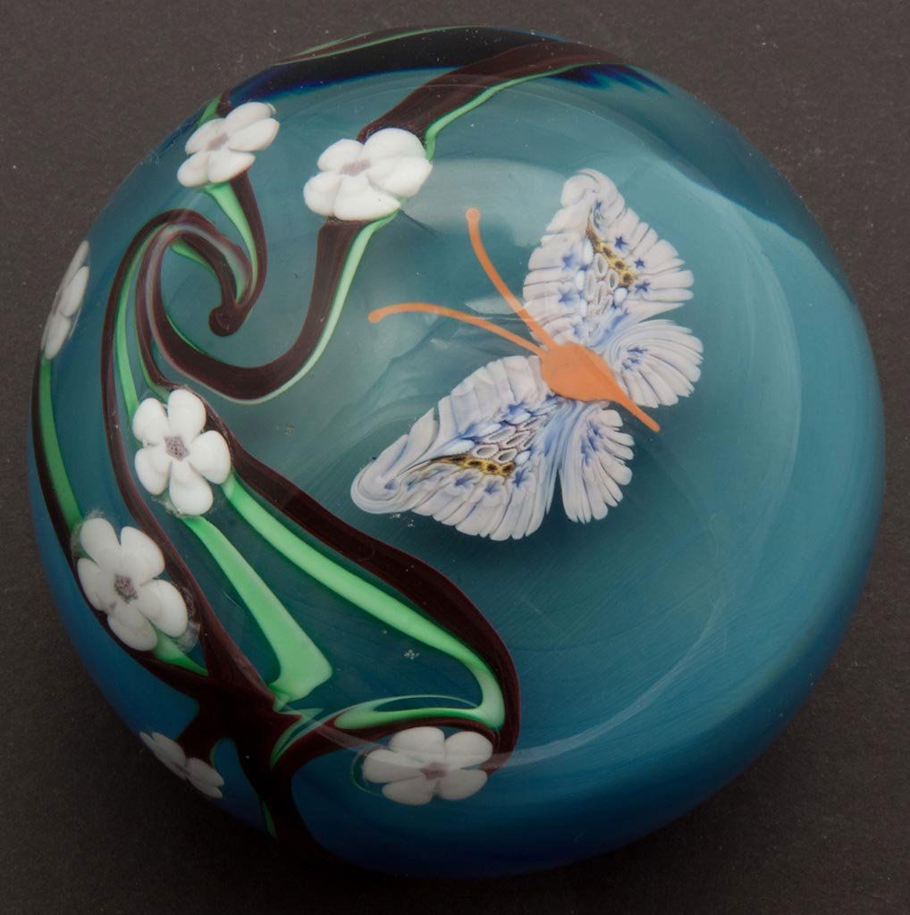 ORIENT & FLUME STUDIO GLASS PAPERWEIGHT: ORIENT & FLUME STUDIO GLASS PAPERWEIGHT, depicting a cane-wing butterfly and flowering vine on shaded blue ground, signed and dated 1979. 2 5/8" H, 3 1/8" D.Provenance: Collection of Lloyd and Nan Gra