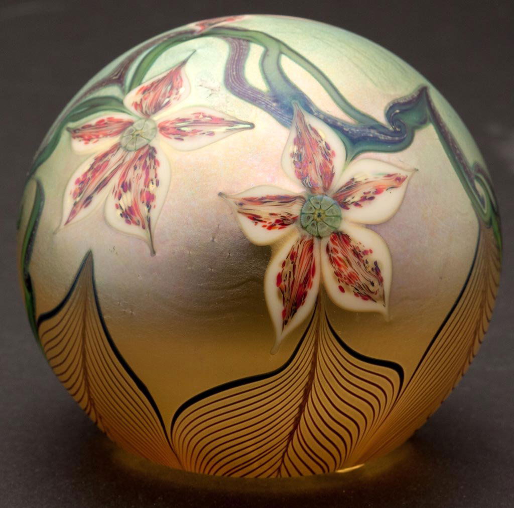 ORIENT & FLUME STUDIO GLASS PAPERWEIGHT: ORIENT & FLUME STUDIO GLASS PAPERWEIGHT, gold iridescent with flowering vine on the crown and six pulled feathers surrounding the base, signed and dated 1978. 2 3/4" H, 3 1/8" D.Provenance: Collection