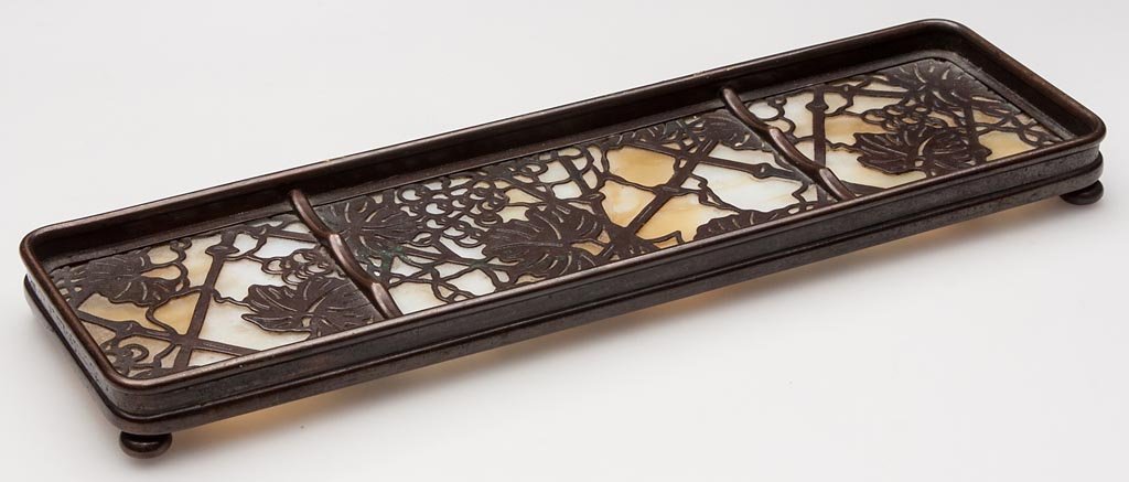 TIFFANY STUDIOS GRAPEVINE PEN TRAY: TIFFANY STUDIOS GRAPEVINE PEN TRAY, patinated-bronze frame with caramel slag glass insert, marked "TIFFANY STUDIOS / NEW YORK" and "1004" to underside. First quarter 20th century. 2 7/8" x 9 5/8".