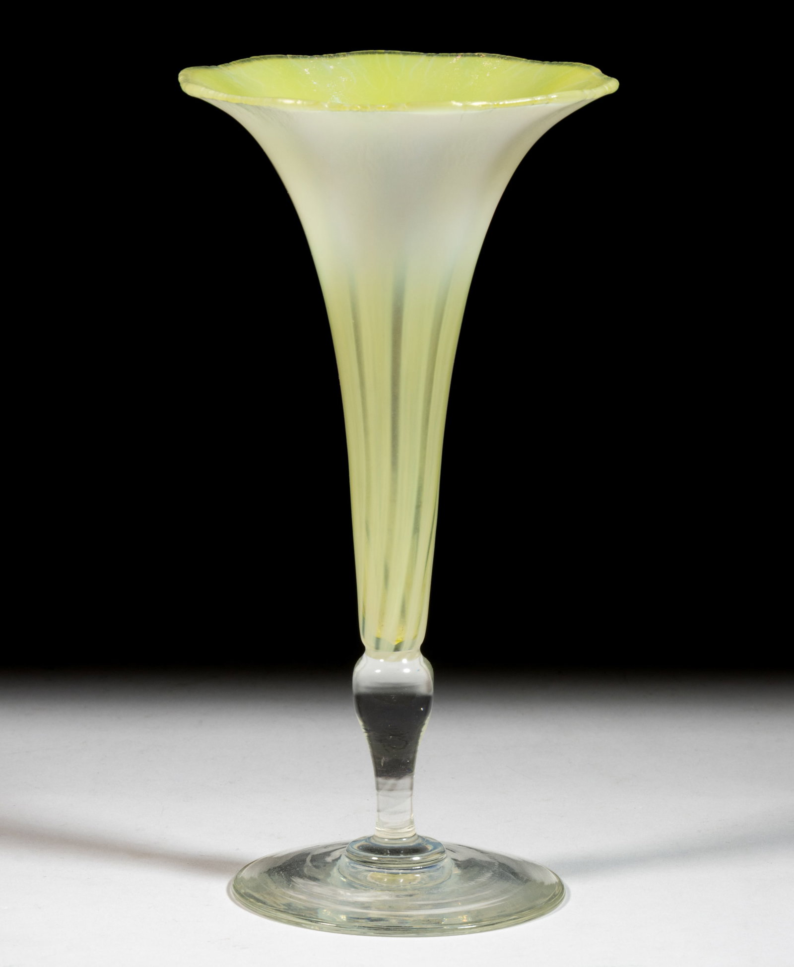 TIFFANY FAVRILE PASTEL ART GLASS TRUMPET VASE: TIFFANY FAVRILE PASTEL ART GLASS TRUMPET VASE, yellow and colorless with opalescent design, fluted bowl with flared rim, raised on a tapered stem with round foot, signed "L.C.T. / Favrile / 1881&