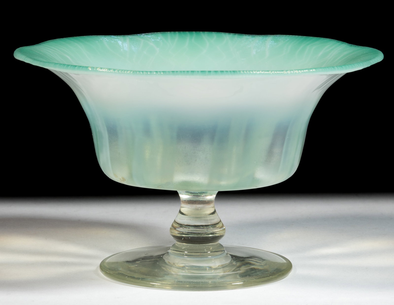 TIFFANY FAVRILE PASTEL ART GLASS FOOTED BOWL: TIFFANY FAVRILE PASTEL ART GLASS FOOTED BOWL, green and colorless with opalescent design, applied foot with a polished pontil mark, signed "L.C.T. / Favrile / 1922". Tiffany Studios. Ci