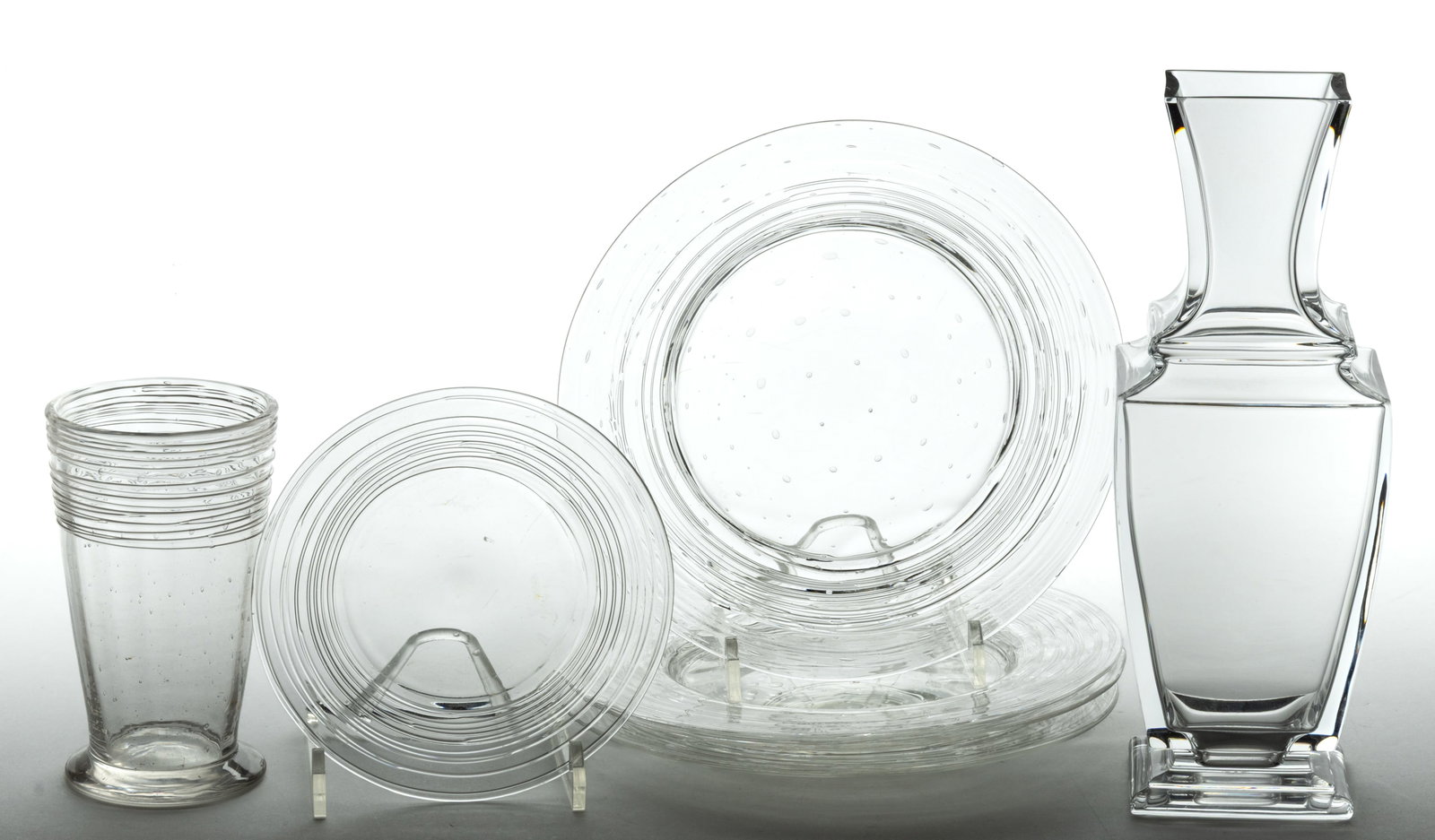 STEUBEN REEDED ART GLASS ARTICLES, LOT OF SIX: STEUBEN REEDED ART GLASS ARTICLES, LOT OF SIX, colorless, comprising four 8 1/2" plates, a 6" plate, and a footed tumbler; 8 1/2" plates and tumbler each having scattered air