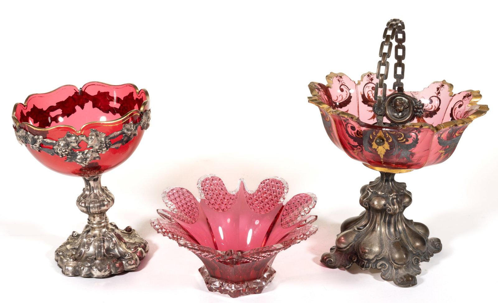ASSORTED BOHEMIAN GLASS ARTICLES, LOT OF THREE: ASSORTED BOHEMIAN GLASS ARTICLES, LOT OF THREE, cranberry, comprising a compote with gilt decoration to the rim raised on metal-plated base with grape and vine border, a compote with gi