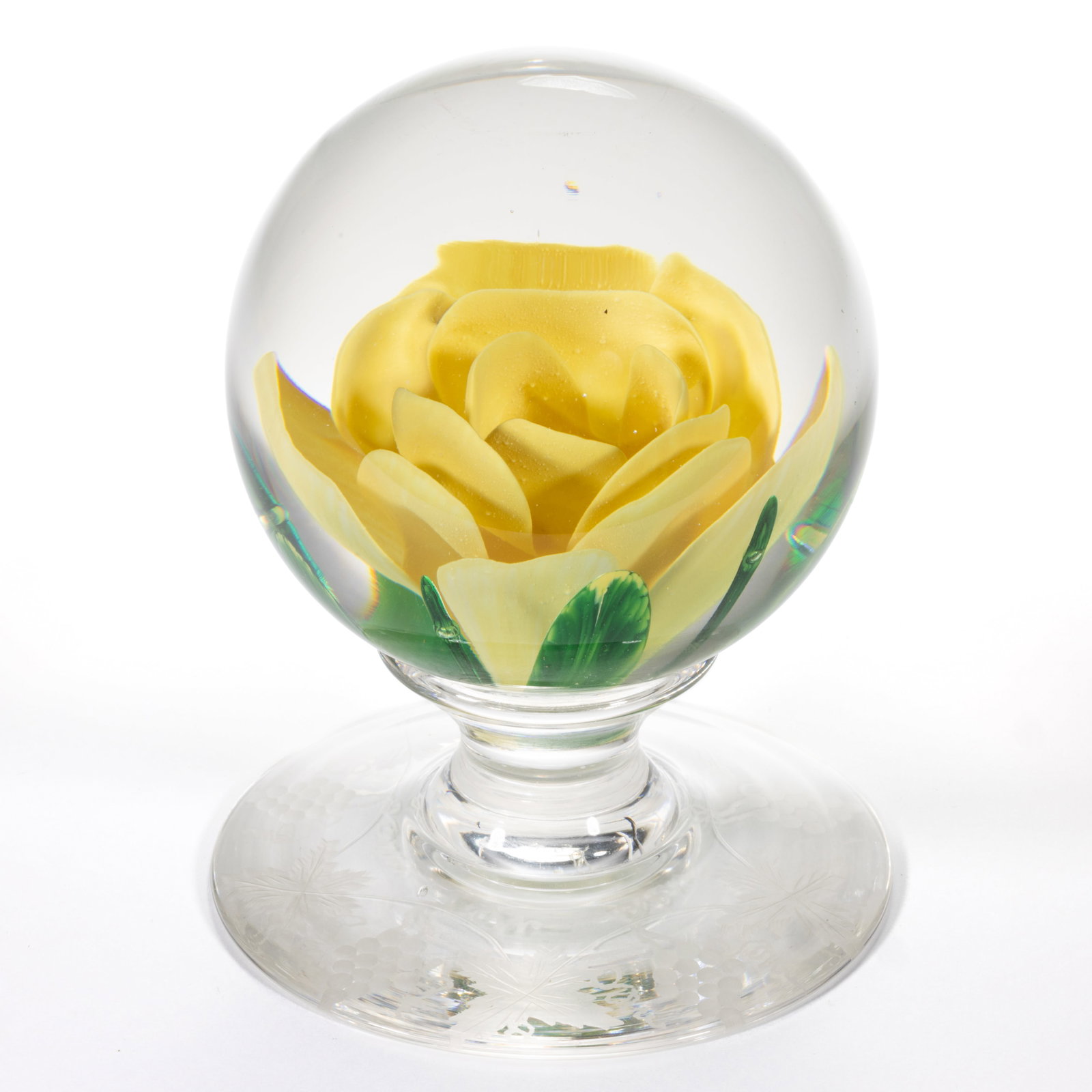 VINTAGE PAIRPOINT CRIMP ROSE - ENGRAVED ART GLASS PEDESTAL PAPERWEIGHT: VINTAGE PAIRPOINT CRIMP ROSE - ENGRAVED ART GLASS PEDESTAL PAPERWEIGHT, containing a large yellow crimp rose with green leaves and blades protruding from below, signature cane to the undersi