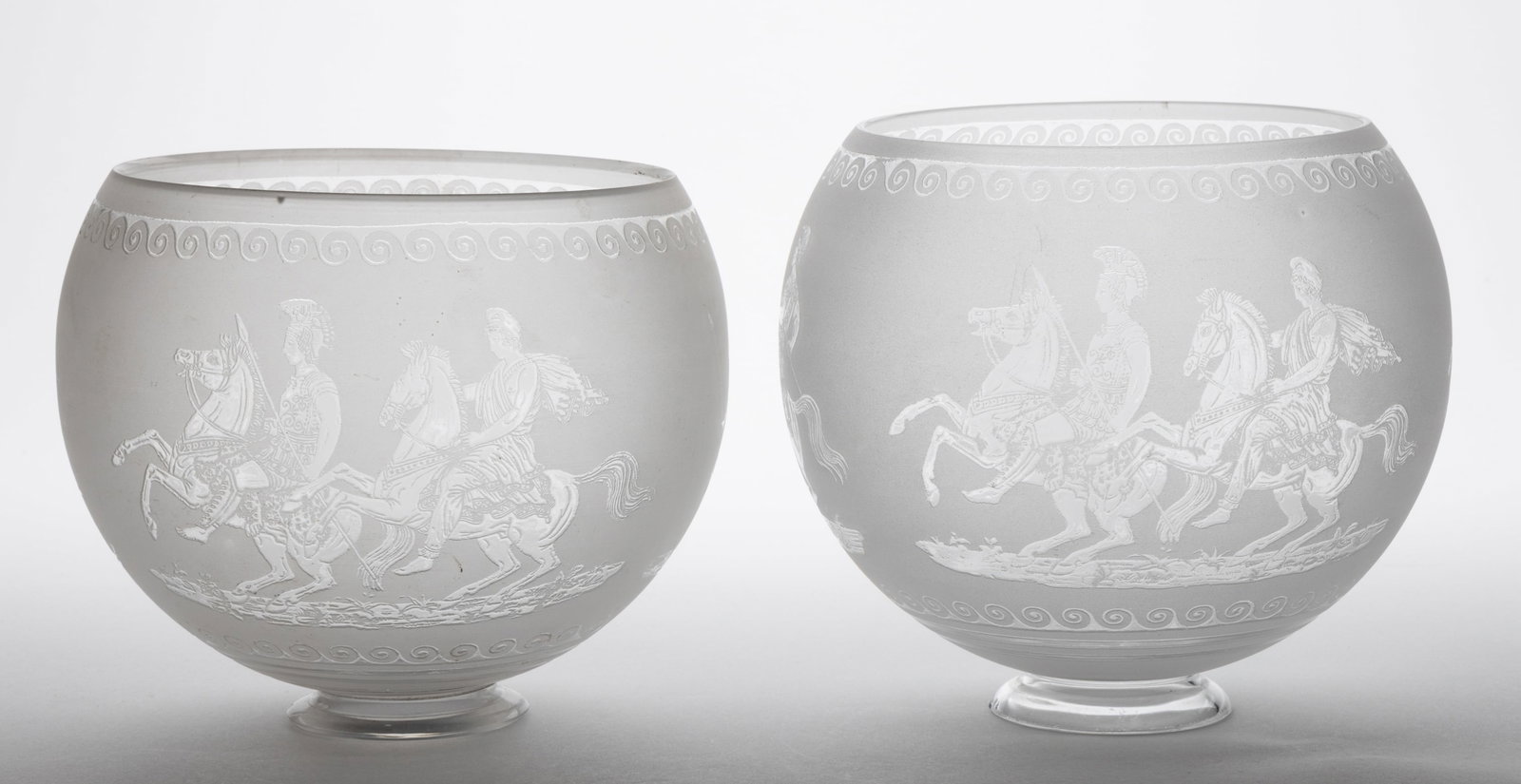BLOWN DEEP ACID-ETCHED GAS LAMP SHADES, NEAR PAIR: BLOWN DEEP ACID-ETCHED GAS LAMP SHADES, NEAR PAIR, colorless with frosted finish, globular form, each with three various Roman Gladiator and chariot scenes between scroll bands. Probably 20th cen