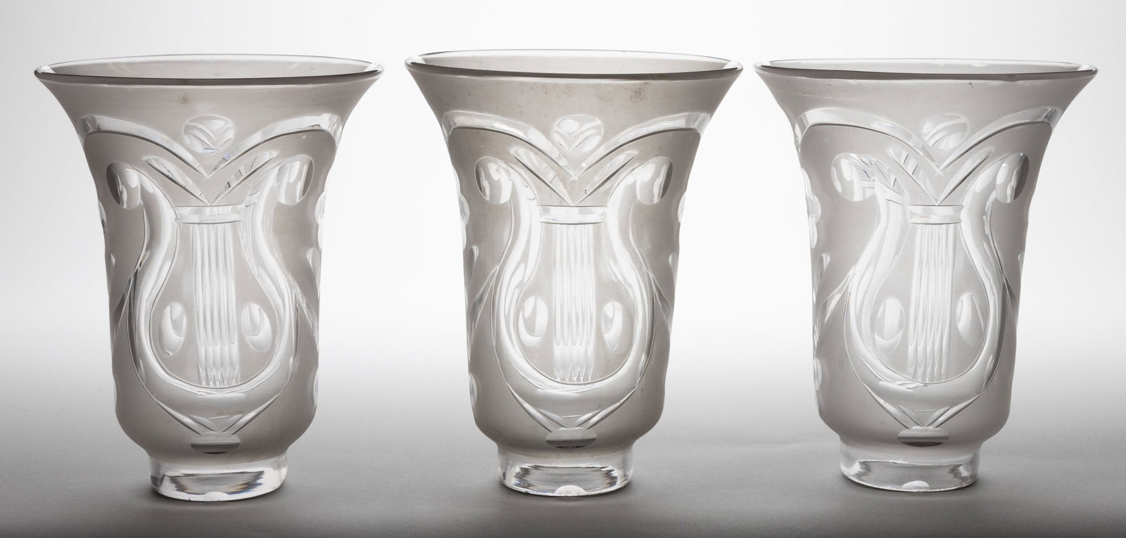 BLOWN CUT AND ENGRAVED ARGAND LAMP SHADES, SET OF THREE: BLOWN CUT AND ENGRAVED ARGAND LAMP SHADES, SET OF THREE colorless with frosted finish, tapered cylinder forms with flared rim, each with cut/engraved lyre, floral and foliage decoration. each wit