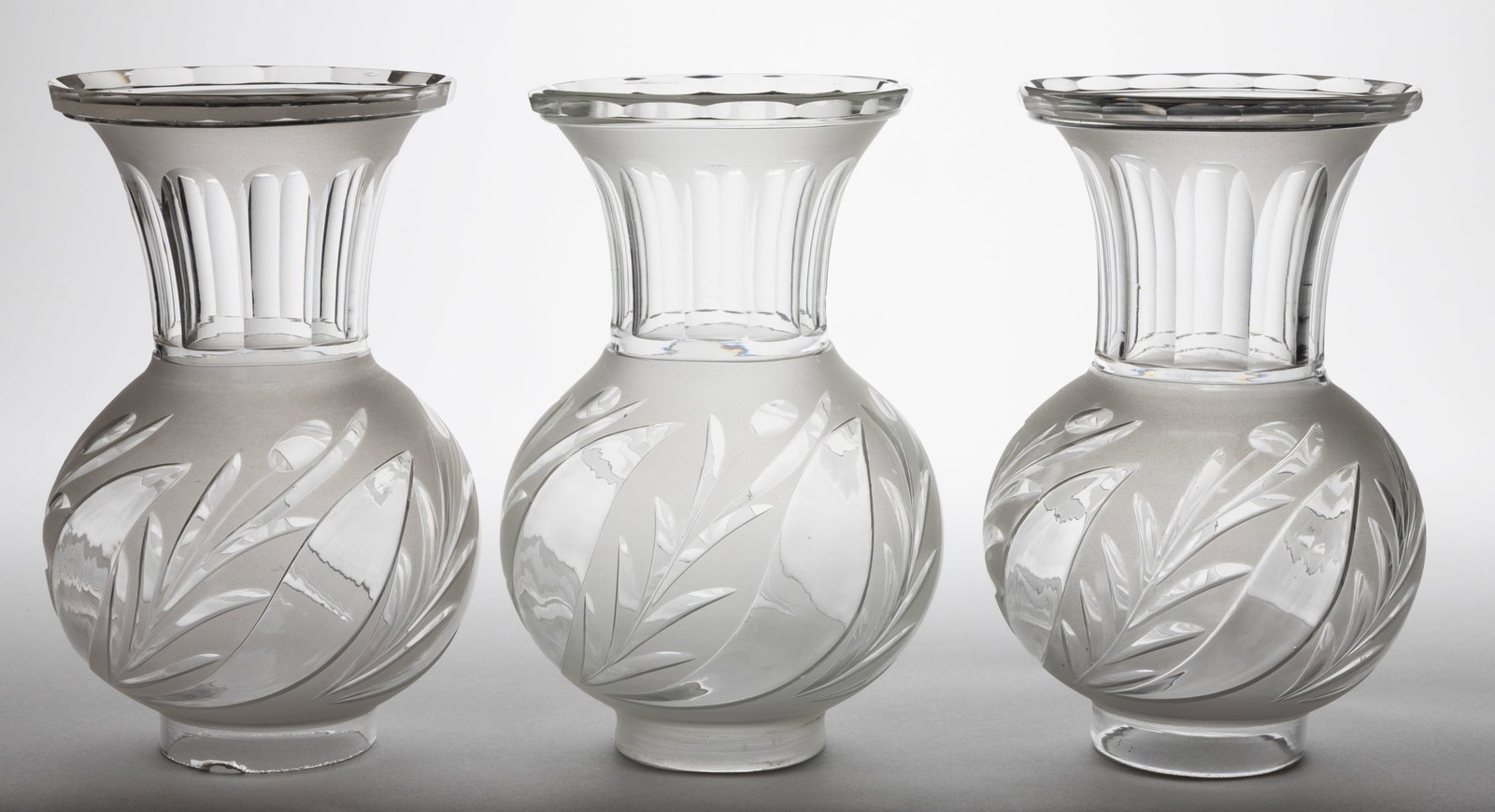 BLOWN CUT AND ENGRAVED ARGAND LAMP SHADES, SET OF THREE: BLOWN CUT AND ENGRAVED ARGAND LAMP SHADES, SET OF THREE, colorless with frosted finish, trumpet forms, each with cut/engraved cattail-type foliage decoration, elongated necks with