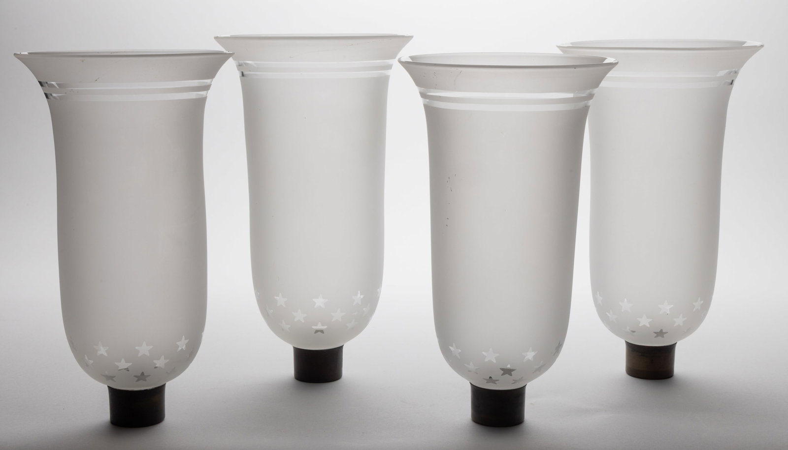 MODERN BLOWN ACID-ETCHED CANDLE SCONCE SHADES, SET OF FOUR: MODERN BLOWN ACID-ETCHED CANDLE SCONCE SHADES, SET OF FOUR, colorless with frosted finish, tapered cylinder forms, topped with two straight line bands and base with a grouping band of five-point stars