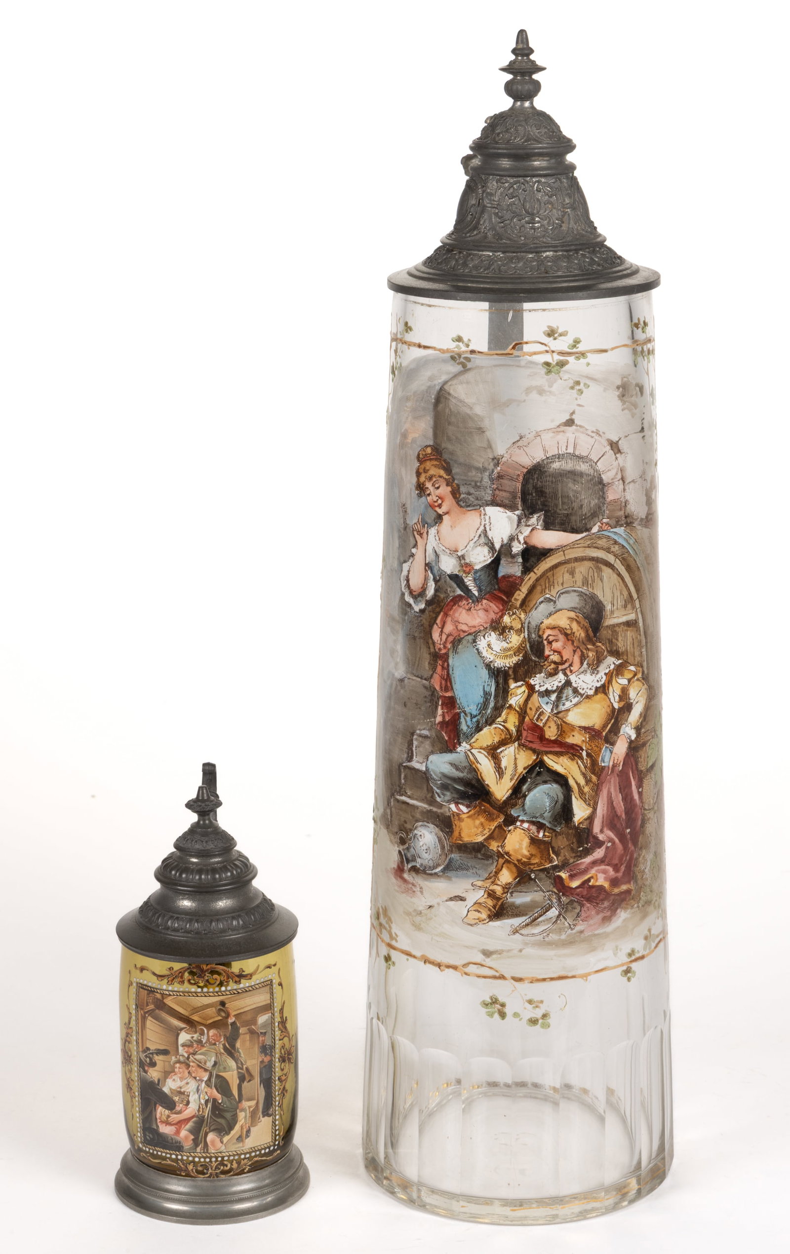BOHEMIAN ENAMEL-DECORATED GLASS STEINS, LOT OF TWO: BOHEMIAN ENAMEL-DECORATED GLASS STEINS, LOT OF TWO, comprising a colorless slightly tapered-form depicting a man sitting by a barrel with a woman looking on and an amber barrel-form with a s