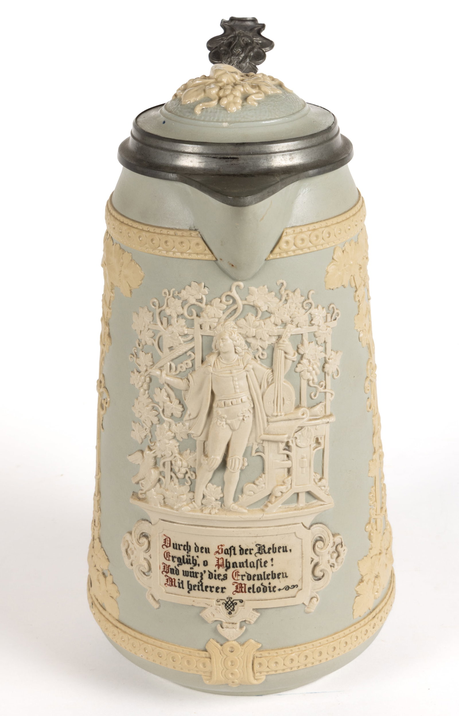 GERMAN METTLACH RELIEF-DECORATED CERAMIC MASTER STEIN: GERMAN METTLACH RELIEF-DECORATED CERAMIC MASTER STEIN, mold number 1821, side panels decorated with grapes, vines and leaves and at center a musician with a lute and under written "Through t
