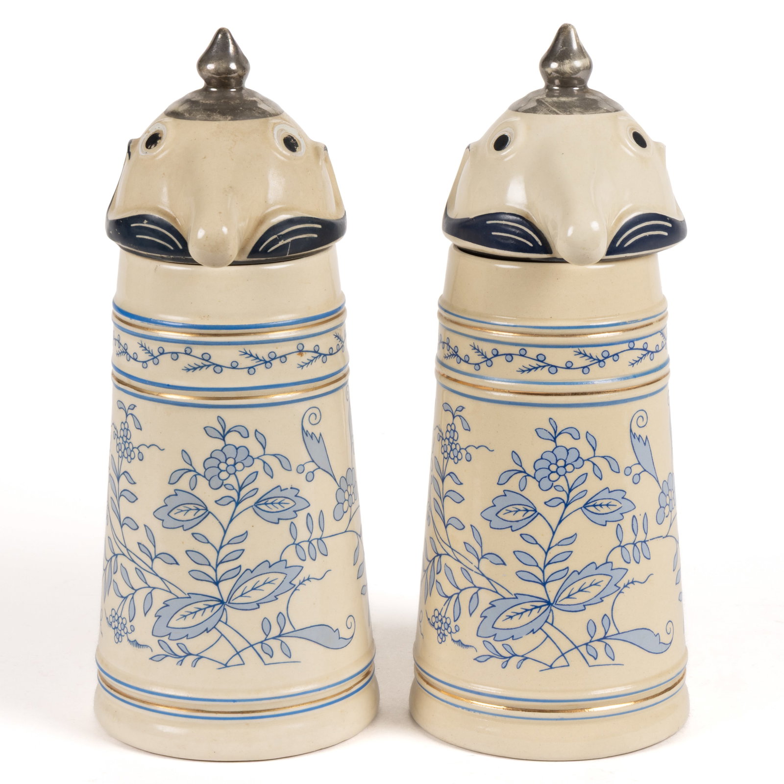 GERMAN WEBCO SCHULTZ CHARACTER CERAMIC PAIR OF STEINS: GERMAN WEBCO SCHULTZ CHARACTER CERAMIC PAIR OF STEINS, each having off-white body with blue floral design, blue and gold accents, ceramic lids with mustache, eyes, and silver finial on top a