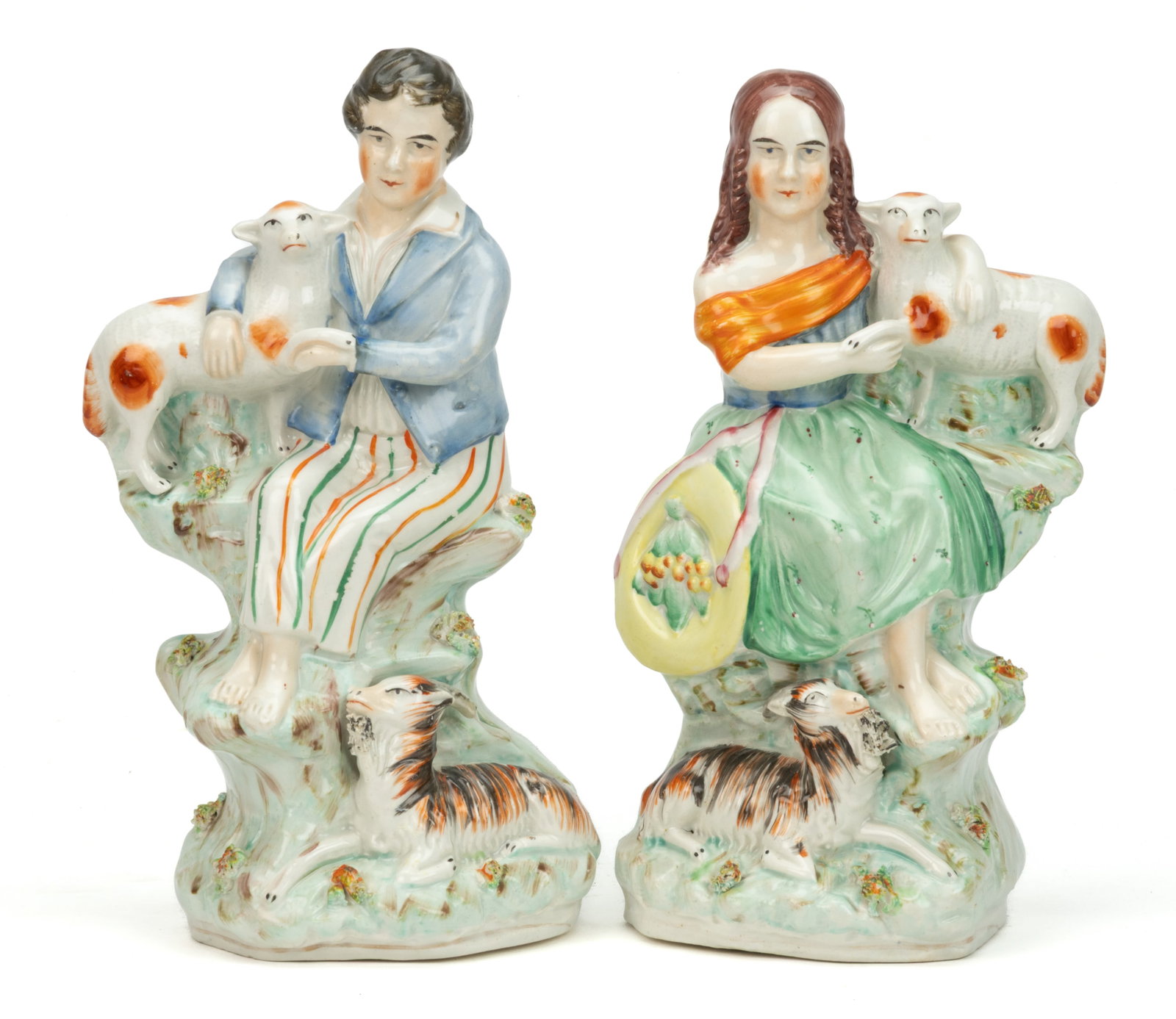 ENGLISH STAFFORDSHIRE HAND-PAINTED CERAMIC CHILDREN AND SHEEP FIGURAL GROUP PAIR: ENGLISH STAFFORDSHIRE HAND-PAINTED CERAMIC CHILDREN AND SHEEP FIGURAL GROUP PAIR, each having polychrome enamel decorations, featuring a barefoot boy and girl sitting cross-legged on a rock