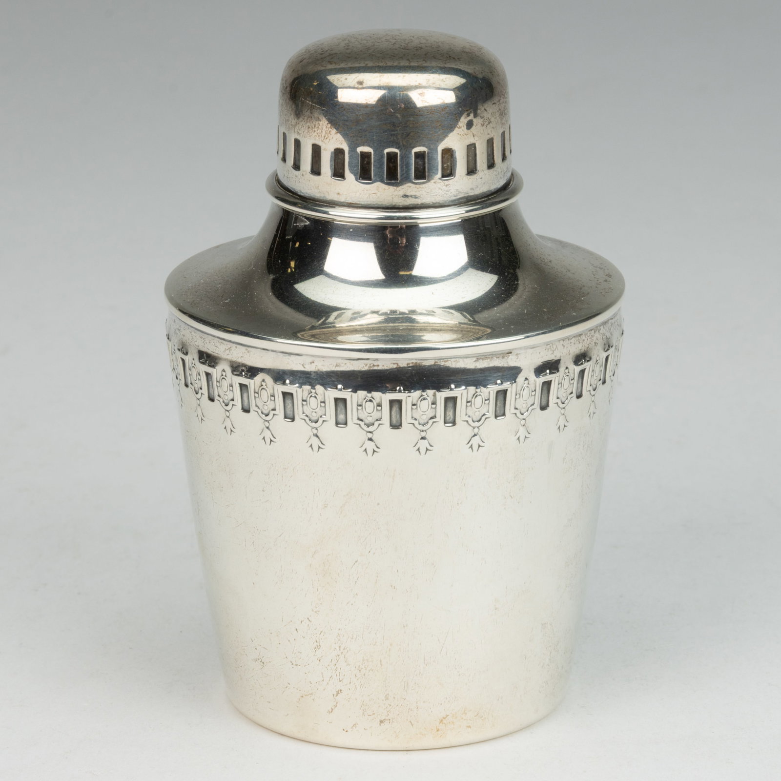 REED & BARTON STERLING SILVER TEA CADDY: REED & BARTON STERLING SILVER TEA CADDY, tapered cylindrical form with sloped shoulder, having a band featuring rectangular notches alternating with flower and medallion motifs, topped by a domed