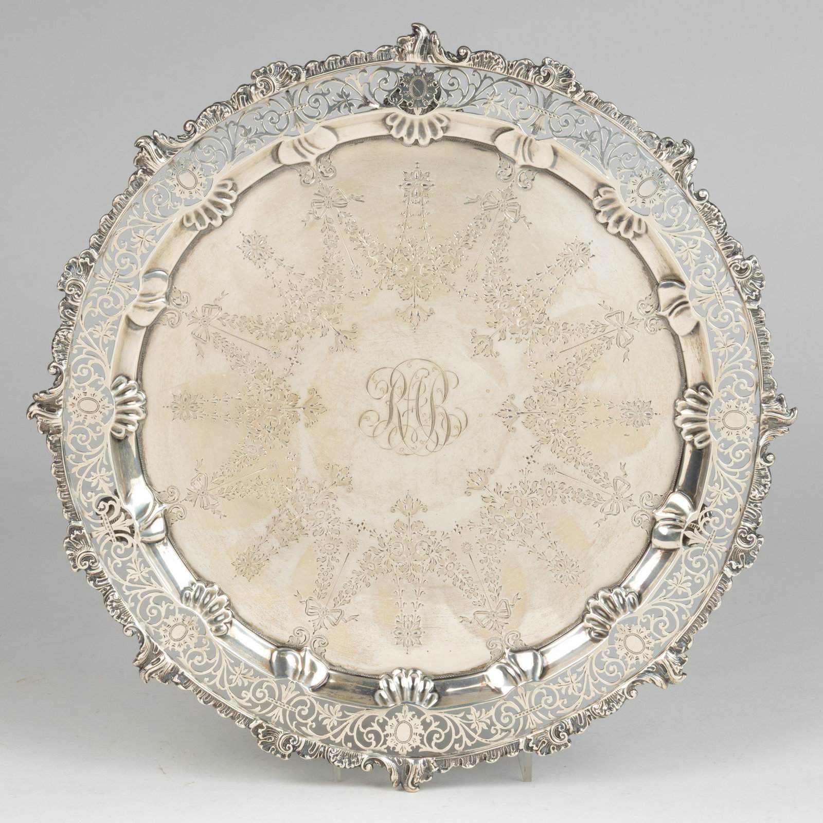 JOSIAH WILLIAMS & CO., ENGLISH EDWARDIAN STERLING SILVER SALVER: JOSIAH WILLIAMS & CO., ENGLISH EDWARDIAN STERLING SILVER SALVER, round form featuring a reticulated rim with scrolled and foliate designs bordered by a shell exterior edge and an embossed shell an
