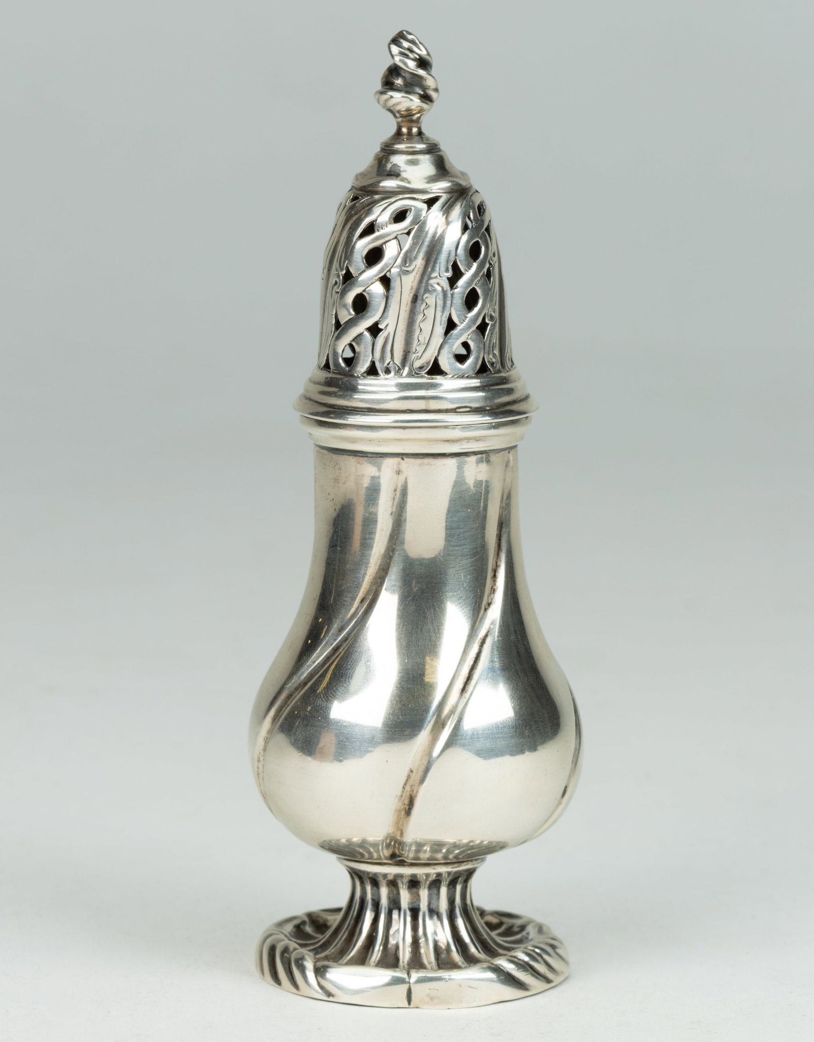 HENDRIK BOSHART, 18TH CENTURY DUTCH SILVER SHAKER: HENDRIK BOSHART, 18TH CENTURY DUTCH SILVER SHAKER, baluster form well with twist fluted accents, topped by a reticulated cap with braided motifs and a flame finial, raised on a fluted pedestal-type fo