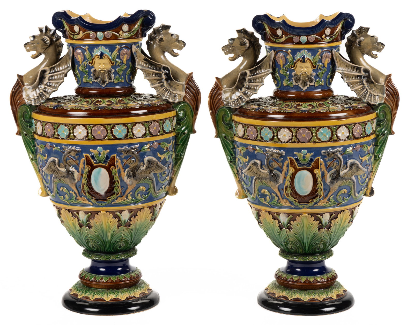 BOHEMIAN MAJOLICA CERAMIC VASE PAIR: BOHEMIAN MAJOLICA CERAMIC VASE PAIR, each of baluster form, having bold polychrome decorations with figural winged dragon handles and a pair of dragons to body with additional acanthus leaf