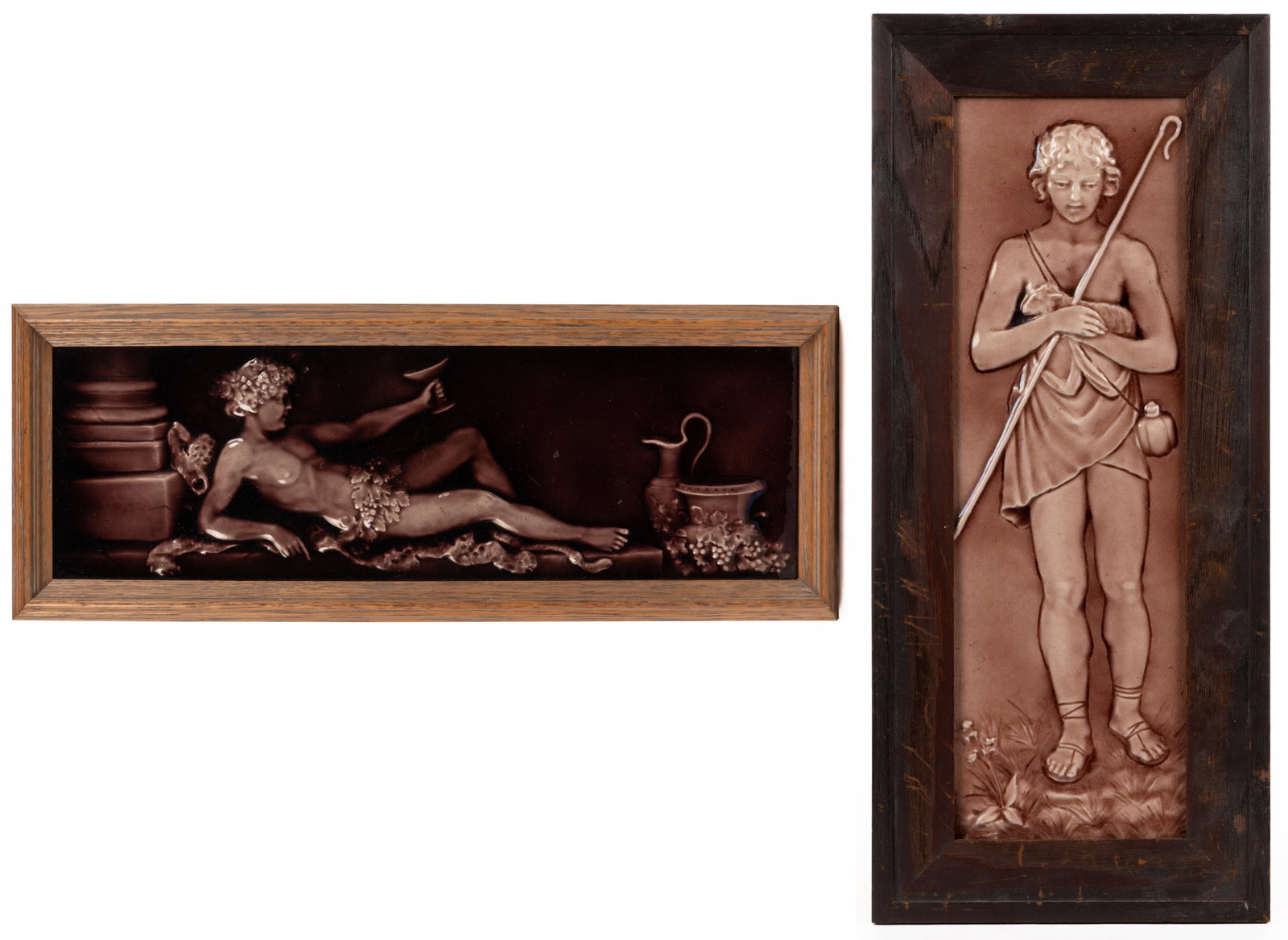 AMERICAN MAJOLICA CERAMIC FRAMED TILES, LOT OF TWO: AMERICAN MAJOLICA CERAMIC FRAMED TILES, LOT OF TWO, each of rectangular form and featuring relief decorations, comprising one example depicting a young man wearing grape leave reclining on an animal s
