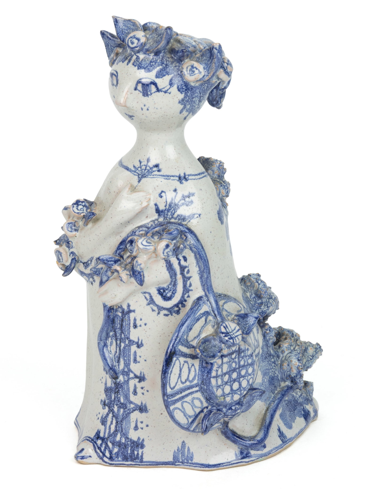 BJORN WIINBLAD (DANISH, 1918-2006) STUDIO POTTERY FIGURE: BJORN WIINBLAD (DANISH, 1918-2006) STUDIO POTTERY FIGURE, depicting a whimsical standing figure with hand-painted blue decoration, holding a wide-brimmed hat over her left arm and a bouquet of fl
